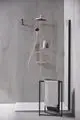 Duschsystem von Ideal Standard mit transparenten Wänden, einem Duschkopf und einer Handbrause, sowie zwei Ablagen für Pflegeprodukte, montiert in einem modernen Raum.
